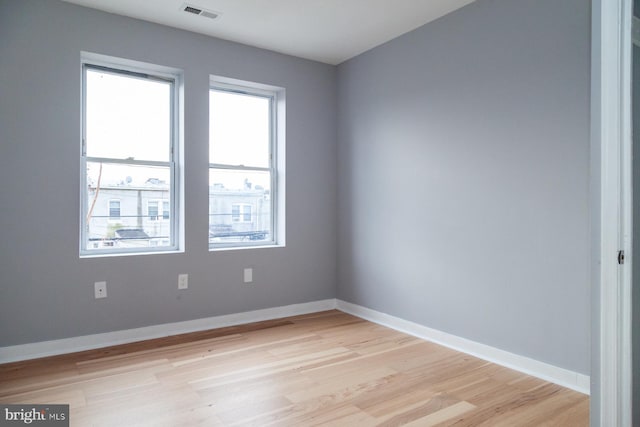 spare room featuring light wood-type flooring and baseboards