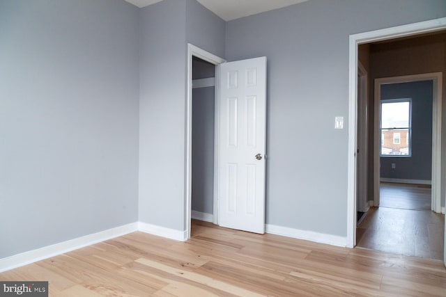 unfurnished bedroom featuring light wood-style flooring and baseboards