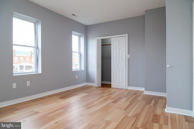 unfurnished bedroom featuring light wood-style flooring and a closet