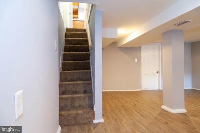 staircase with wood finished floors and baseboards