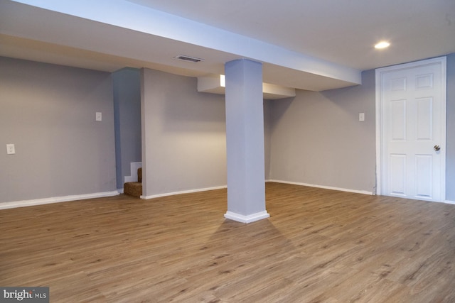 finished basement featuring light wood-type flooring, recessed lighting, and stairway