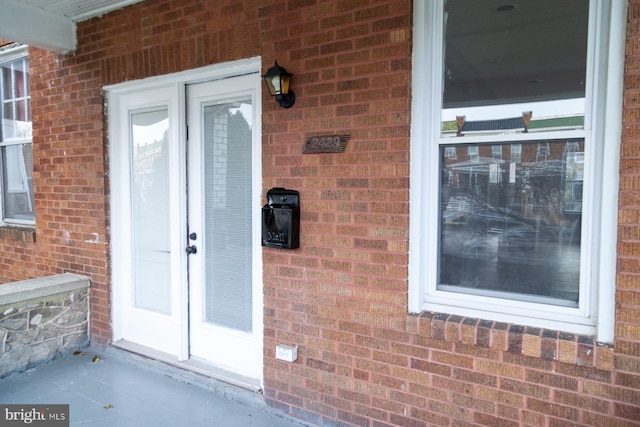 entrance to property featuring brick siding