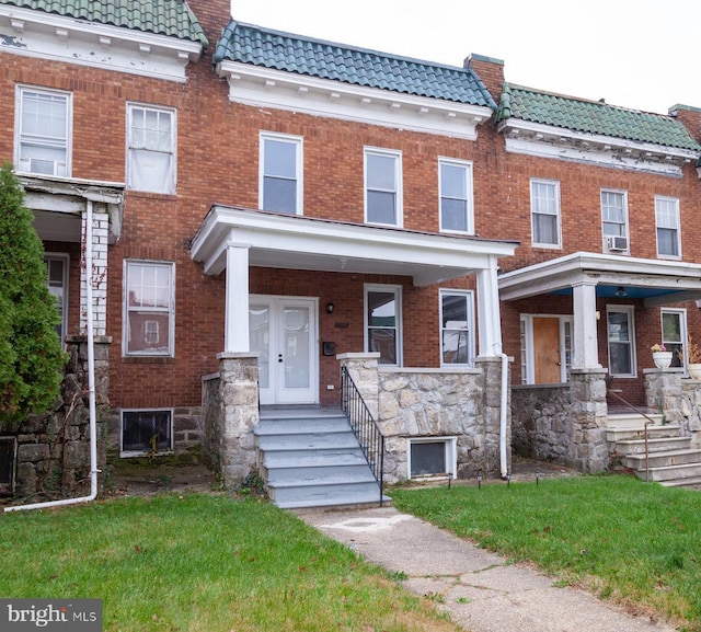 multi unit property featuring a tile roof, a porch, and a chimney