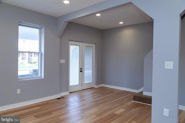 foyer entrance with light wood-style flooring and recessed lighting