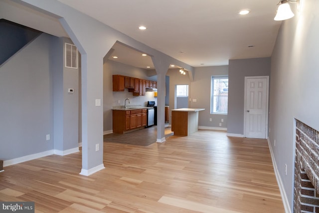 unfurnished living room featuring light wood-style flooring, recessed lighting, and arched walkways