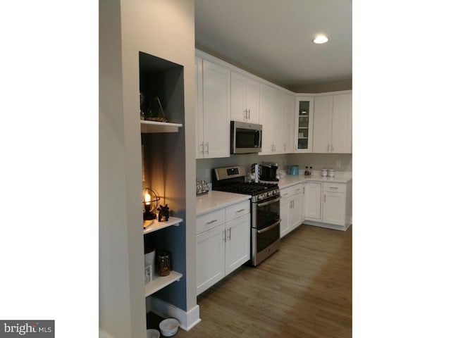 kitchen featuring dark hardwood / wood-style floors, white cabinetry, and appliances with stainless steel finishes