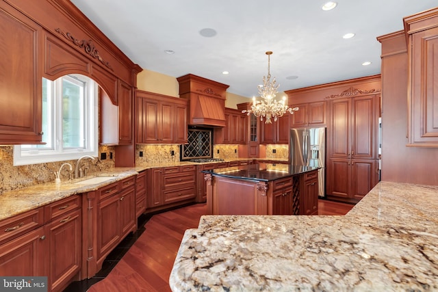 kitchen featuring dark hardwood / wood-style floors, dark stone countertops, backsplash, premium range hood, and sink