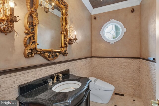 bathroom with toilet, tile walls, ornamental molding, tile patterned floors, and vanity