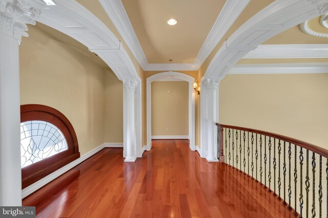 entryway with crown molding, wood-type flooring, and ornate columns