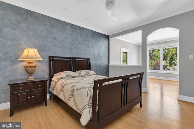 bedroom featuring ceiling fan, light wood-type flooring, and ornamental molding