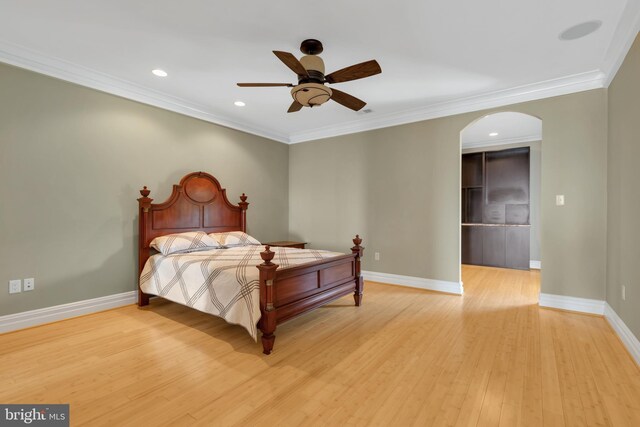 bedroom featuring ceiling fan, crown molding, and light hardwood / wood-style flooring