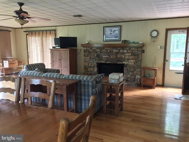 living room with ceiling fan, a fireplace, and hardwood / wood-style flooring