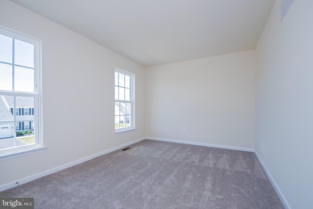 empty room with plenty of natural light and dark carpet