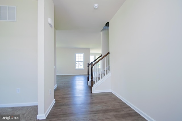 hall with dark colored carpet