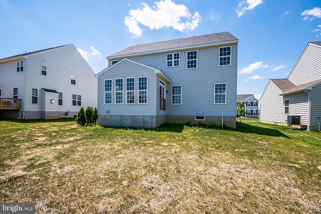 back of property with central air condition unit and a lawn