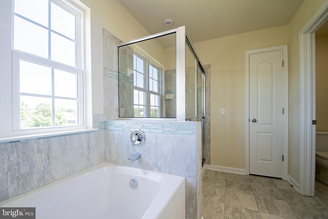 bathroom featuring shower with separate bathtub, toilet, and tile flooring