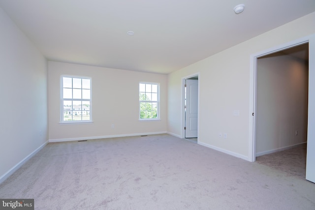 unfurnished room featuring light carpet