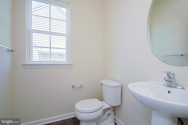 bathroom with sink, toilet, and hardwood / wood-style flooring