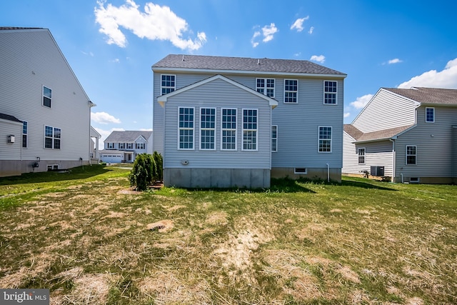 back of house featuring central AC unit and a yard