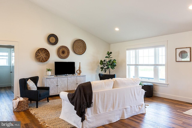 living room with plenty of natural light, vaulted ceiling, and hardwood / wood-style flooring