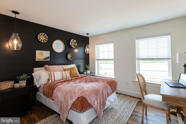 bedroom featuring wooden walls and wood-type flooring