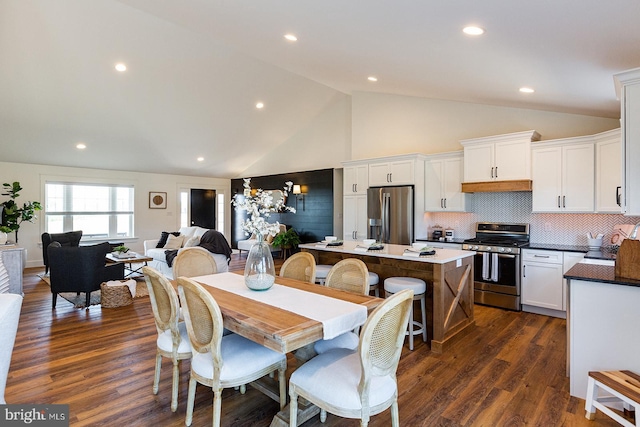 dining area with high vaulted ceiling and dark wood-type flooring