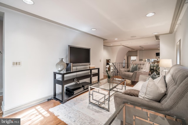 living room with crown molding and light hardwood / wood-style flooring