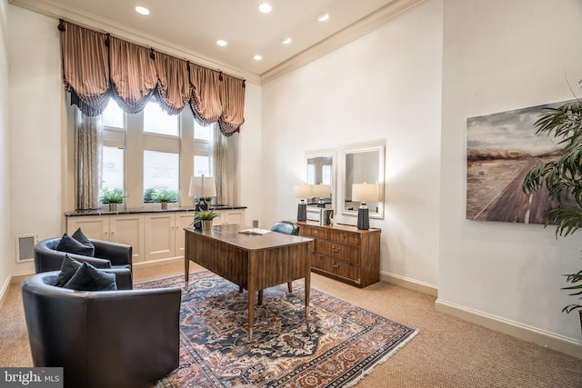 carpeted office featuring a towering ceiling and crown molding