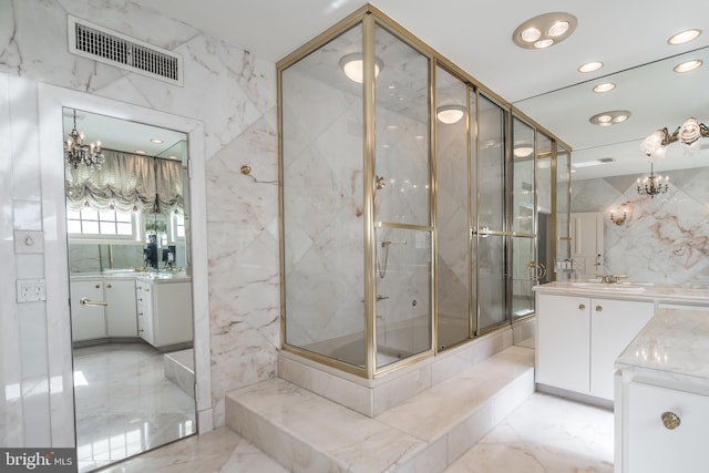 bathroom with vanity, a shower with door, and tile walls