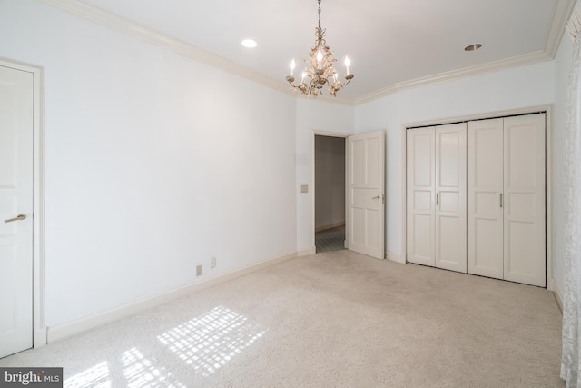 unfurnished bedroom featuring light carpet, crown molding, a closet, and a notable chandelier