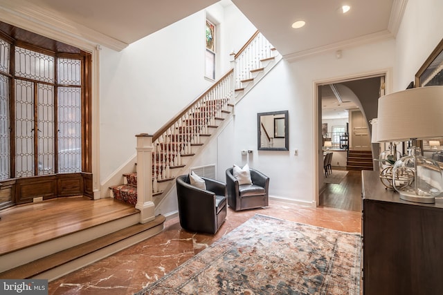 entrance foyer with hardwood / wood-style floors and ornamental molding