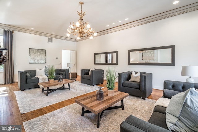 living room featuring an inviting chandelier, crown molding, and light hardwood / wood-style flooring