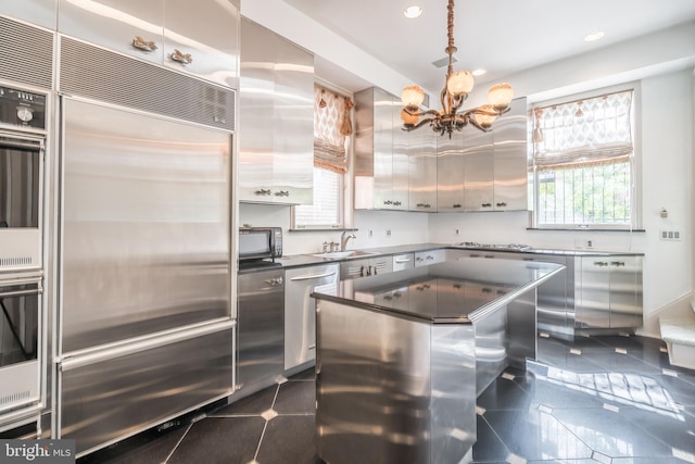 kitchen with sink, appliances with stainless steel finishes, and an inviting chandelier