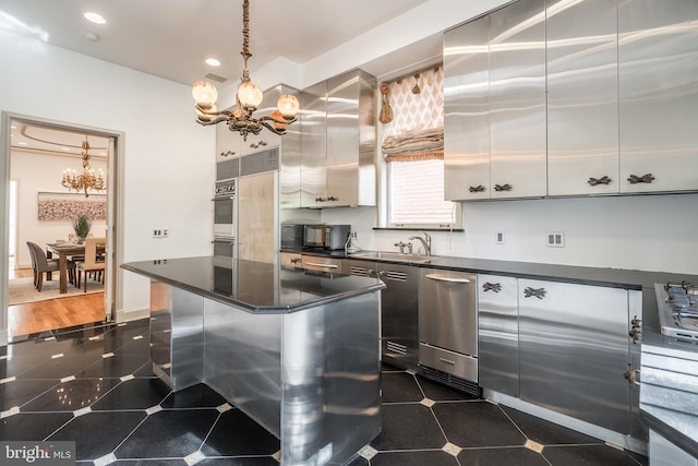 kitchen featuring sink, stainless steel appliances, hanging light fixtures, dark hardwood / wood-style flooring, and a notable chandelier