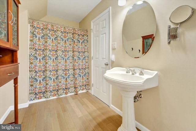 full bath with wood finished floors, a shower with shower curtain, and baseboards