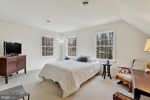 bedroom with visible vents, vaulted ceiling, light carpet, and baseboards