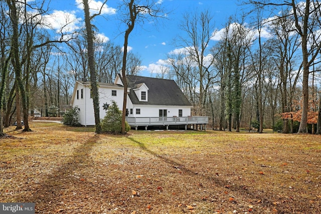 back of property with a lawn and a deck