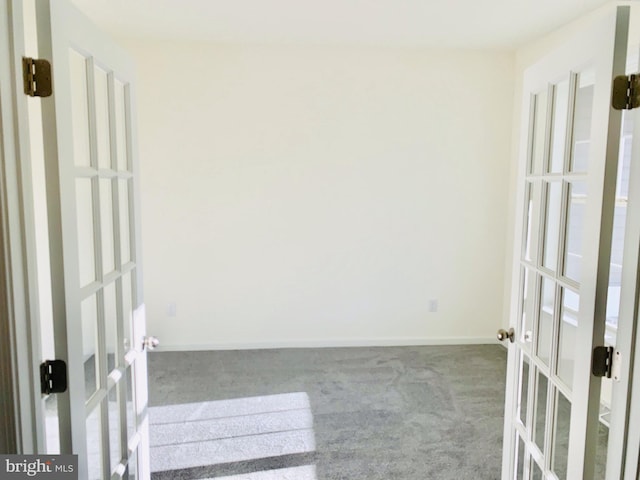 carpeted spare room with french doors