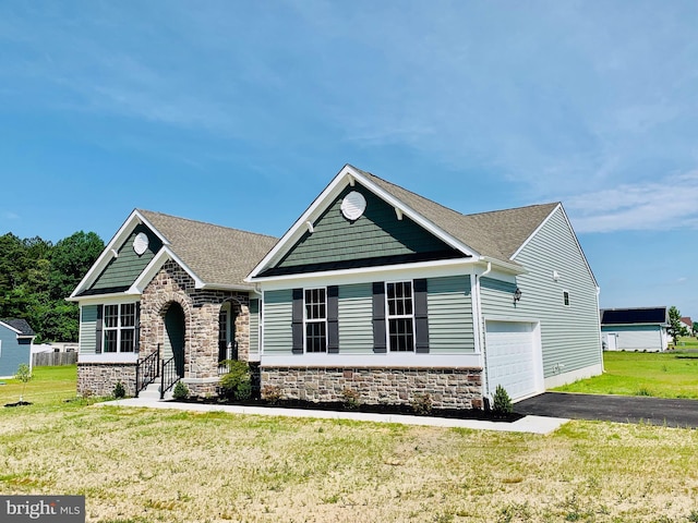 craftsman-style house featuring a garage and a front lawn