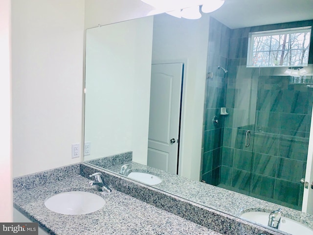 bathroom featuring vanity and a shower with door