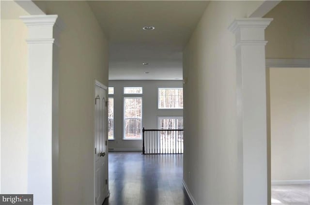 hall with dark hardwood / wood-style floors and ornate columns