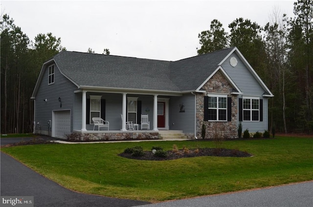 view of front of house with a front lawn, covered porch, and a garage