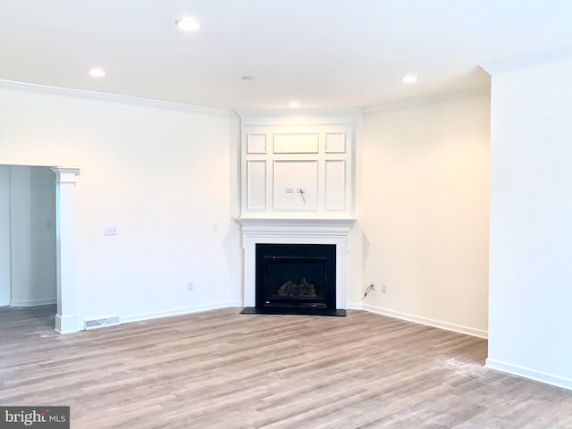 unfurnished living room featuring ornamental molding and light hardwood / wood-style floors