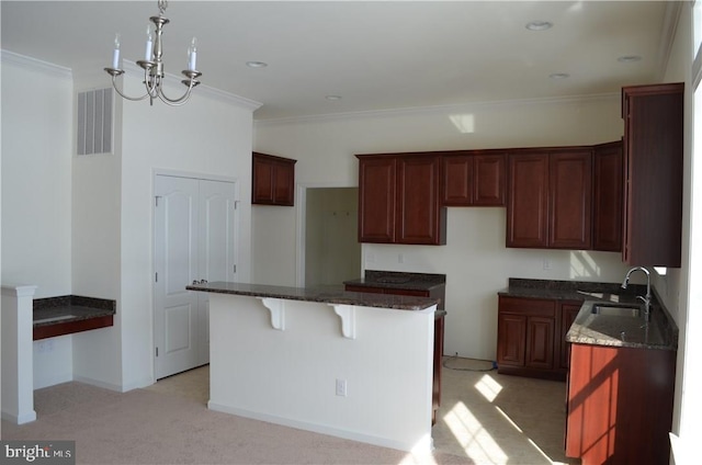 kitchen featuring sink, light colored carpet, a kitchen island, and an inviting chandelier