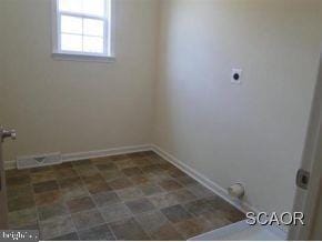 laundry room with electric dryer hookup and tile patterned flooring