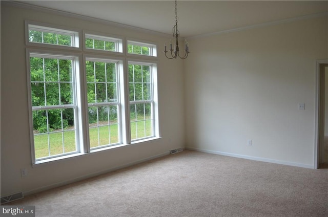 carpeted spare room with a notable chandelier and ornamental molding