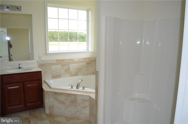 bathroom featuring tiled tub, tile patterned flooring, and vanity