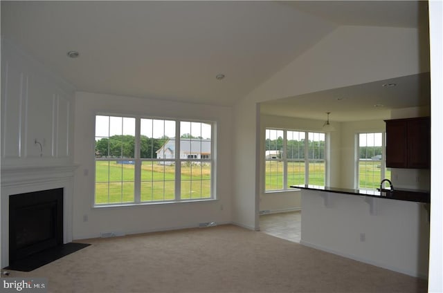 unfurnished living room with light carpet and lofted ceiling