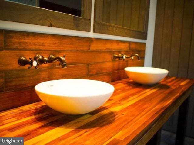 bathroom with wooden walls, hardwood / wood-style floors, and sink