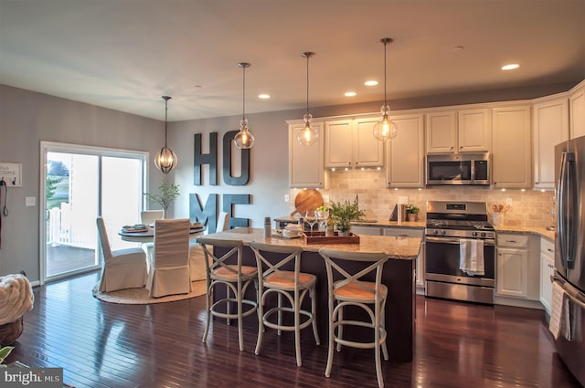 kitchen with dark hardwood / wood-style flooring, white cabinetry, light stone counters, and stainless steel appliances